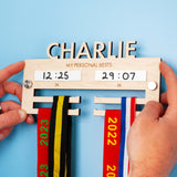 Laser Engraved and Laser Cut Children's Personalised Wooden medal hanger displaying personal best times for two events.