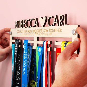 Wooden Personalised Couples Medal Hanger with both first names, a heart and an engraved message with brushed aluminium wall mount fixings