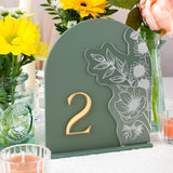 Decorative table number '2' with floral design on a green stand, surrounded by flowers and candles.