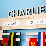 Personalised Wooden medal hanger displaying personal best times for two events, with highly detailed laser engraving and drywipe sections to change the times as they progress