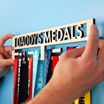 Personalised Minimal Wooden Medal Hanger featuring 'DADDY'S MEDALS' cut out above the Medals hanging below