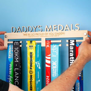 Wooden medal hanger personalised with 'Daddy's Medals' and a heartfelt message engraved on two lines.