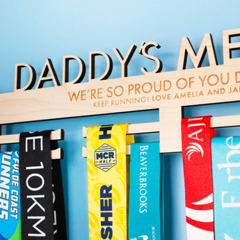 Wooden medal hanger personalised with 'Daddy's Medals' and numerous running medals.