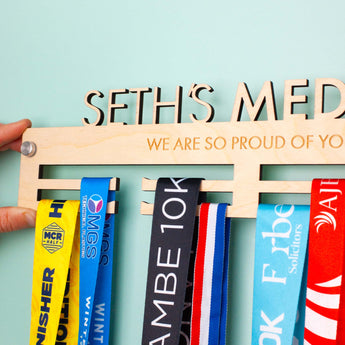 Detailed view of the engraving and the Brushed Aluminium wall mount fixings on a Personalised Wooden Medal Hanger