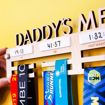 Detailed view of Personalised Wooden Medal Hanger with four dry wipe sections to record personal best times for four events