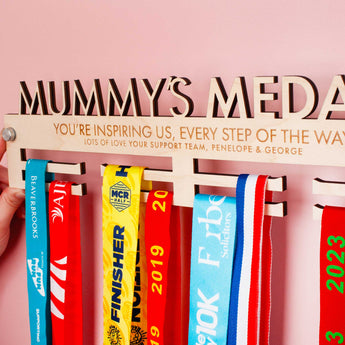 Detailed view of Personalised Medal hanger with 'Mummy's Medals' on top, with a cute message engraved over two lines