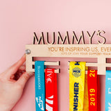 Personalised Medal hanger with 'Mummy's Medals' on top, showing one side of the hanger, with the included Brushed Aluminium Wall Mount Fixings
