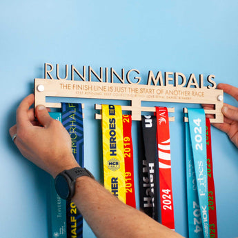Personalised Wooden Medal Hanger that reads 'RUNNING MEDALS' cut out on the top line and 'THE FINISH LINE IS JUST THE START OF ANOTHER RACE' engraved on the next line 