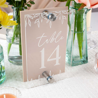 Table number 14 sign with floral design on a table with flowers and candles.