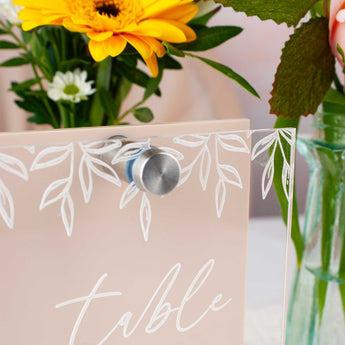 Table number sign with floral design and flowers in the background