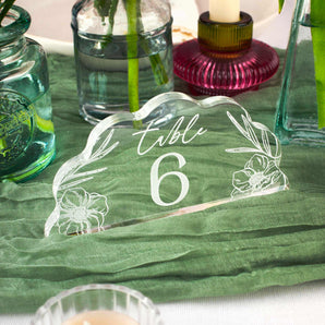 Clear table number 6 with floral designs on a green tablecloth