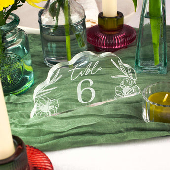 Decorative table number 6 with floral design on a green tablecloth.